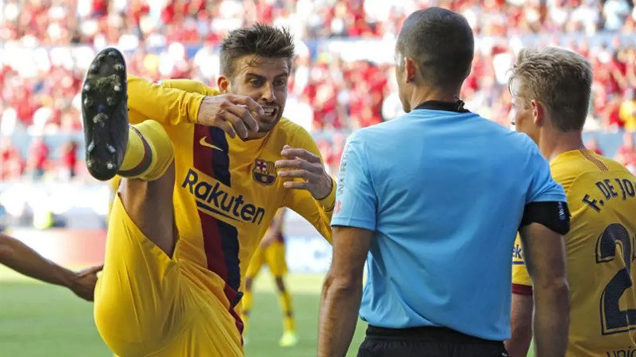 Piqué protesta por un penalti en el partido contra el Osasuna. VILLAR LÓPEZ (EFE)