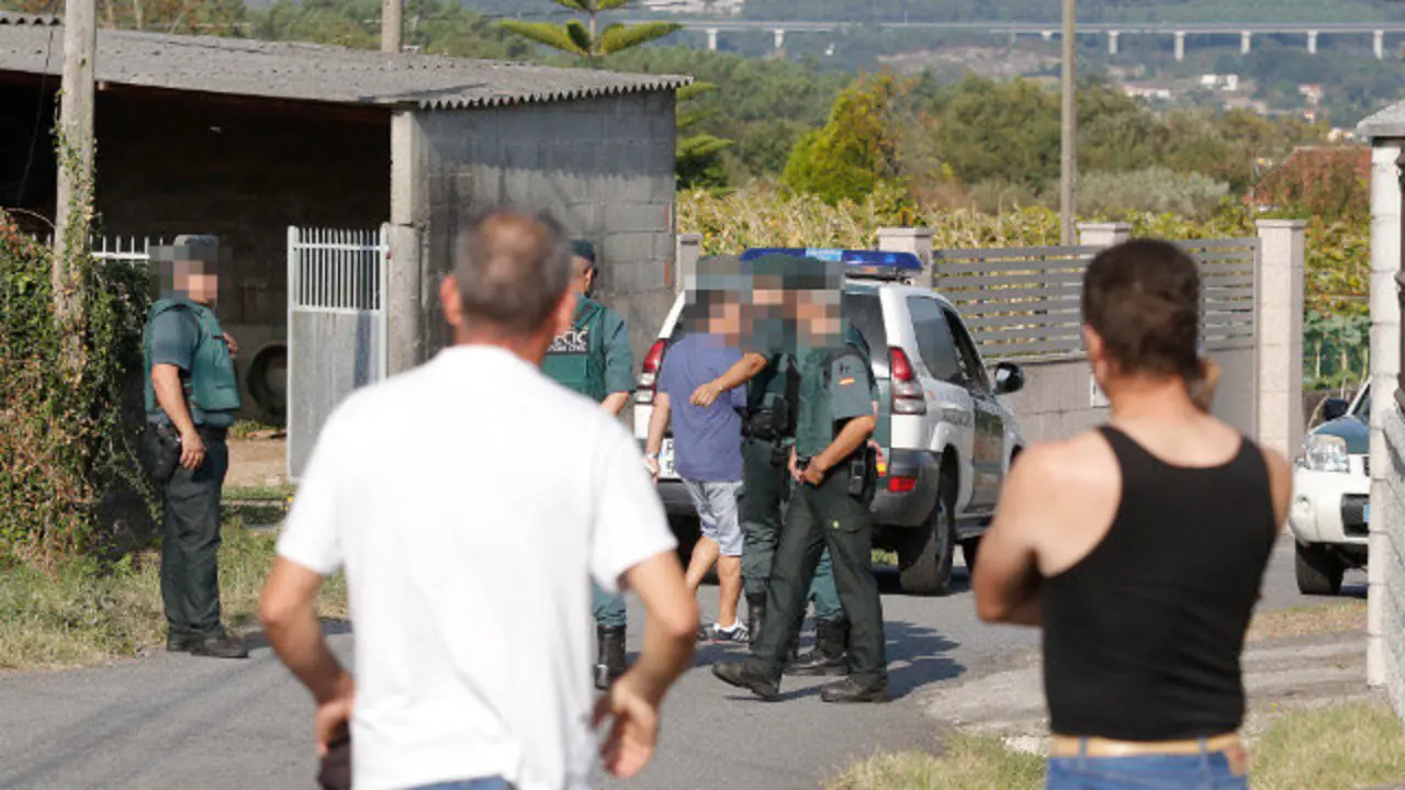 Veciños ante o precinto do triplo crime de Valga. GONZALO GARCÍA