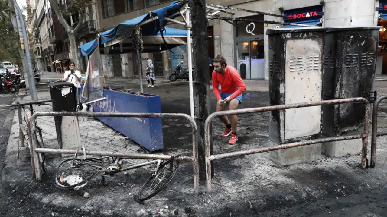 Aspecto que presenta este sábado una de las calles de Barcelona tras los incidentes. JESÚS DIGES (EFE)