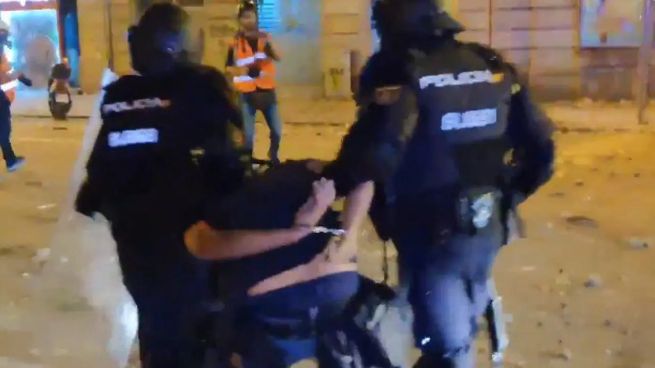 Momento en el que los agentes se llevan al fotógrafo de El País. TWITTER (@GPisarello)