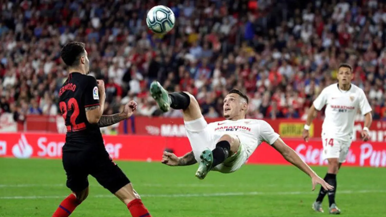 Lucas Ocampos (d) intenta la chilena ante Mario Hermoso, del Atlético. JULIO MUÑOZ