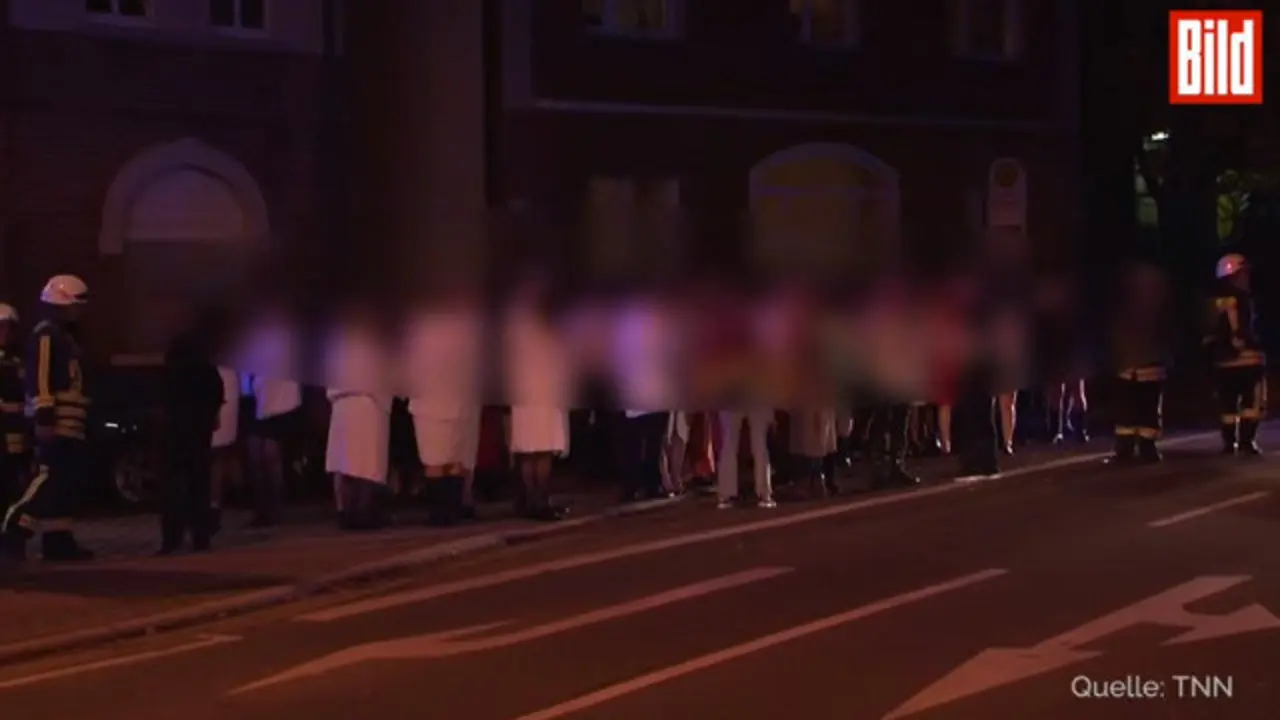 Os participantes na orx&iacute;a, tapados con toallas, na entrada do local. BILD