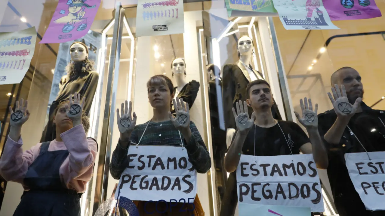 Los activistas, en el escaparate de Zara.