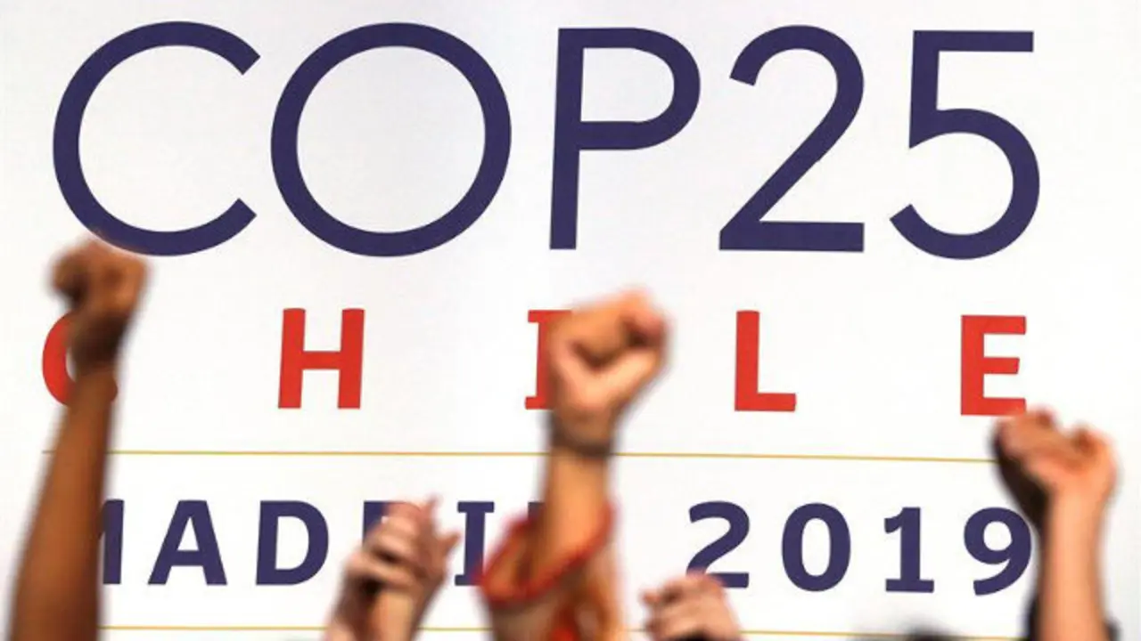 Varios activistas alzan sus puños después de la sesión plenaria de la Cumbre Climática. EFE.