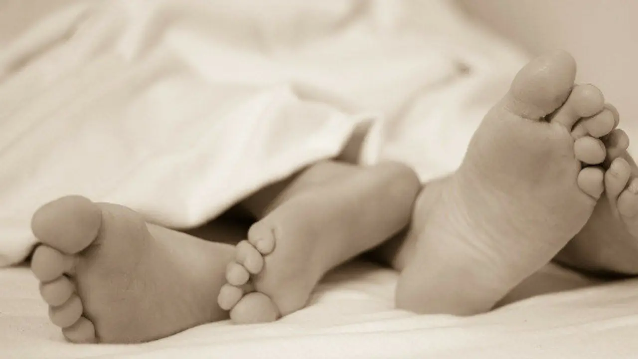 Pés dunha parella nunha cama. EP