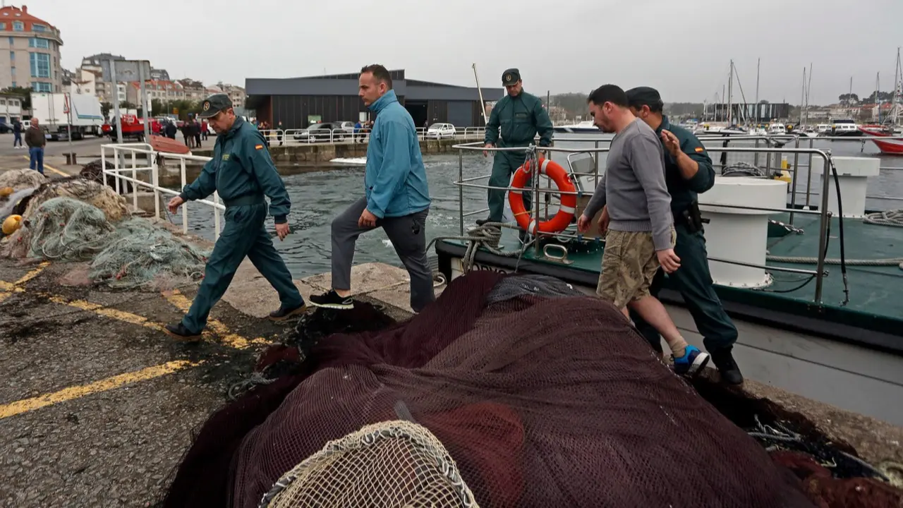 Los dos tripulantes rescatados, en el puerto de Portonovo. JAVIER CERVERA-MERCADILLO