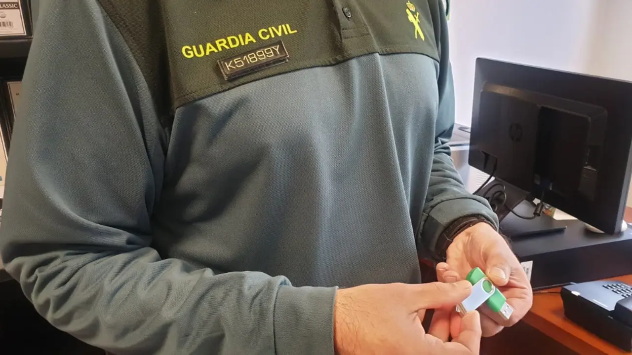 Un agente muestra el pendrive con la obra de la escritora víctima de extorsión. GUARDIA CIVIL