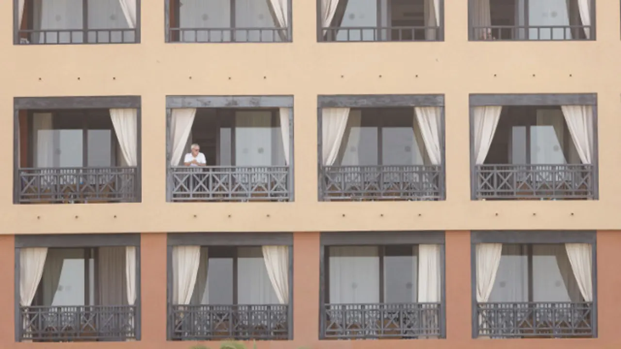 Un turista asómase desde o hotel de Adeje que estivo en corentena polo coronavirus. EFE