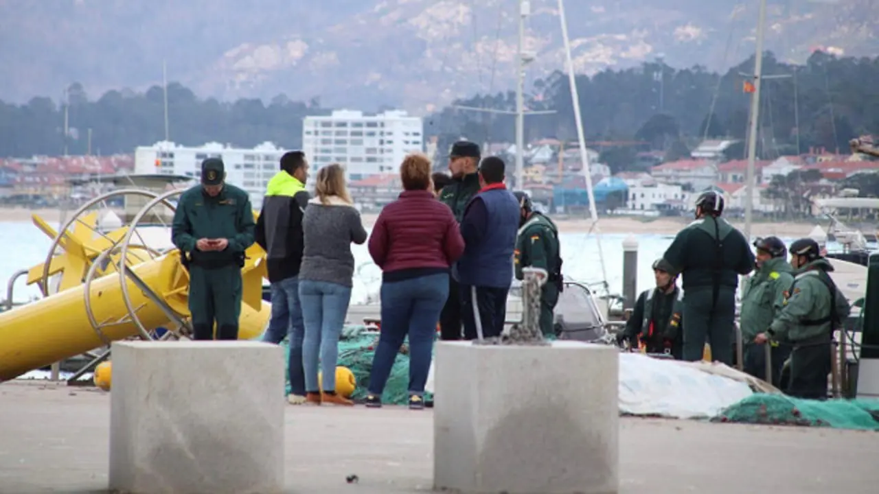 Familiares y agentes de la Guardia Civil, en el puerto de Baiona. SLAVADOR SAS (Efe)