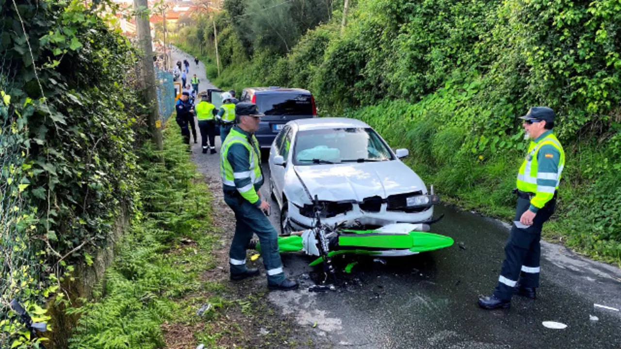 Dous membros da Garda Civil inspeccionan a zona onde unha moto e un turismo sufriron un accidente de tráfico este luns en Cangas. SXENICK (EFE)