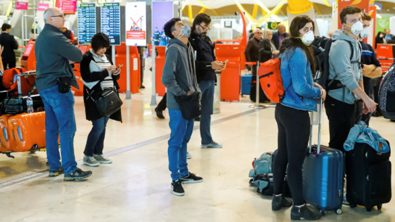 Viajeros con mascarillas en el aeropuerto en Madrid. EFE