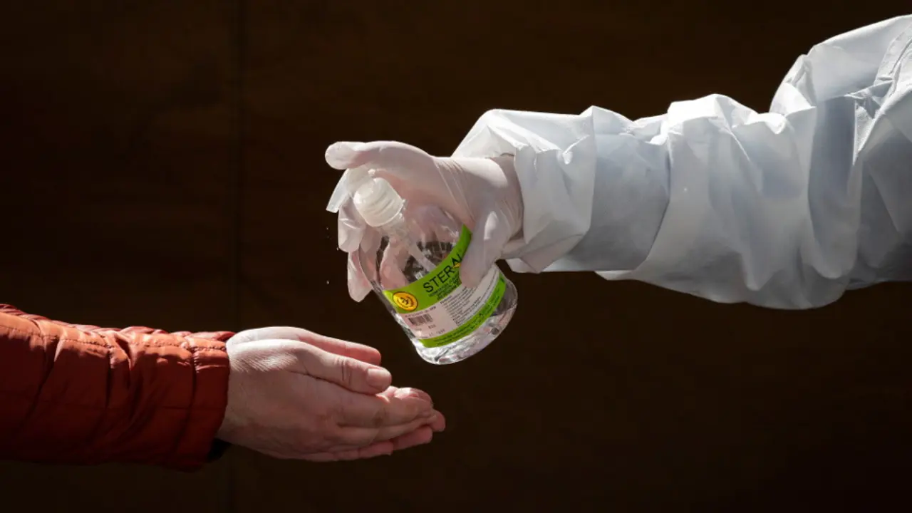 Una persona suministra gel desinfectante a otra. EFE