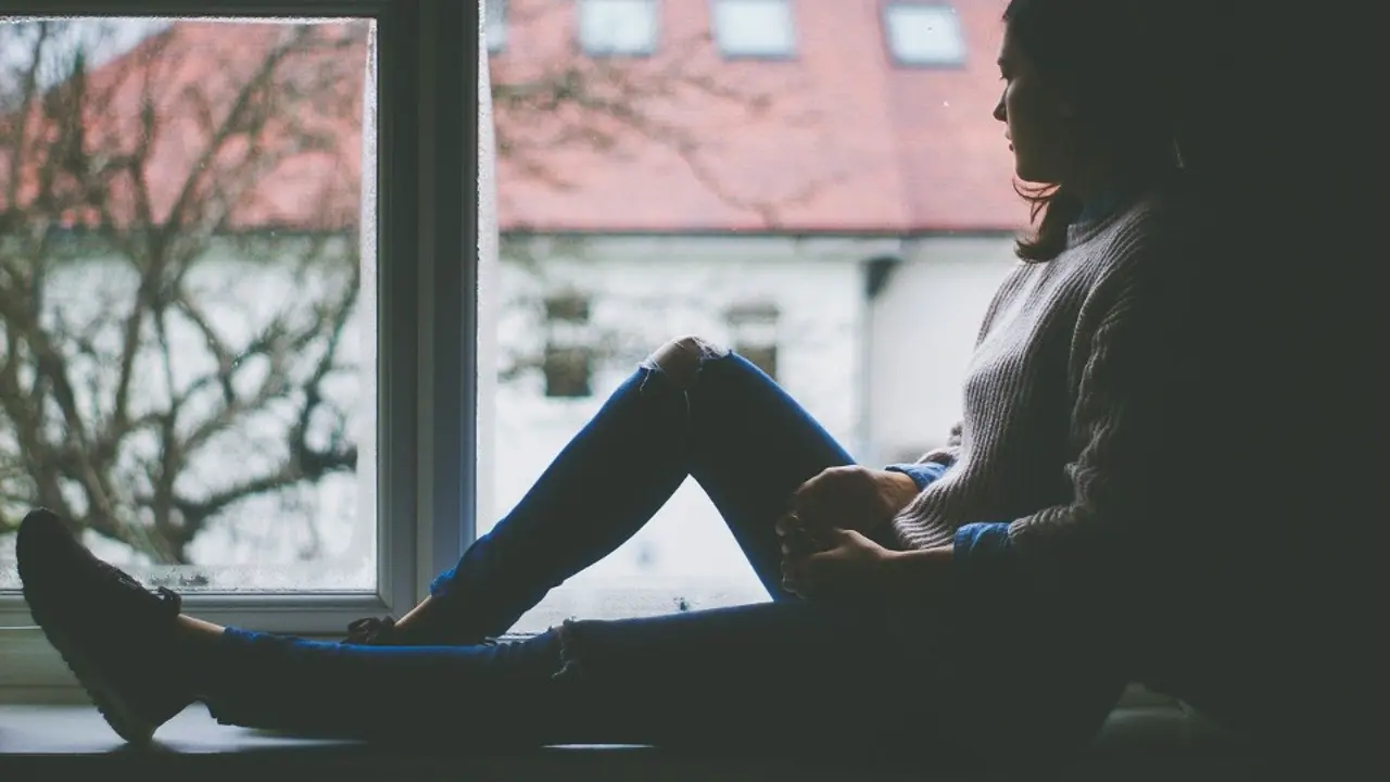 Una joven mira por la ventana. PIXABAY