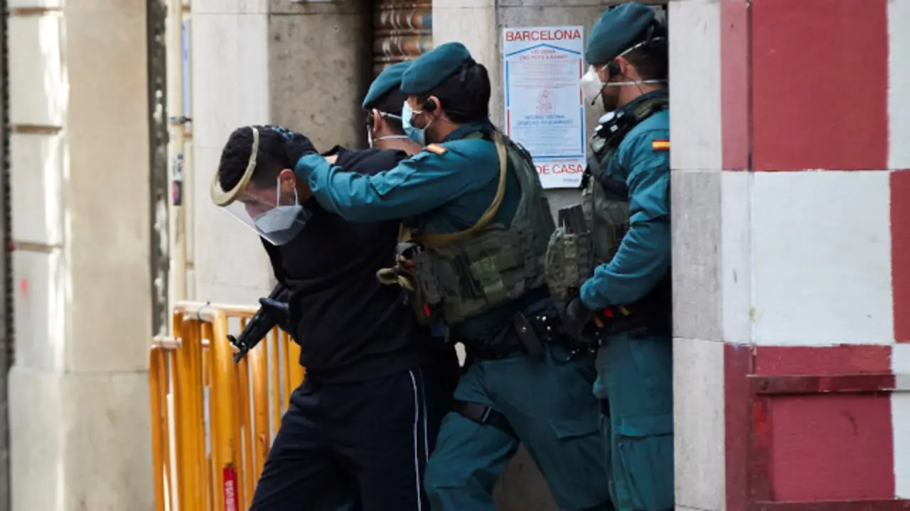 Axentes da Garda Civil custodian, tras o rexistro do seu domicilio, ao seguidor de Dáesh.  EFE