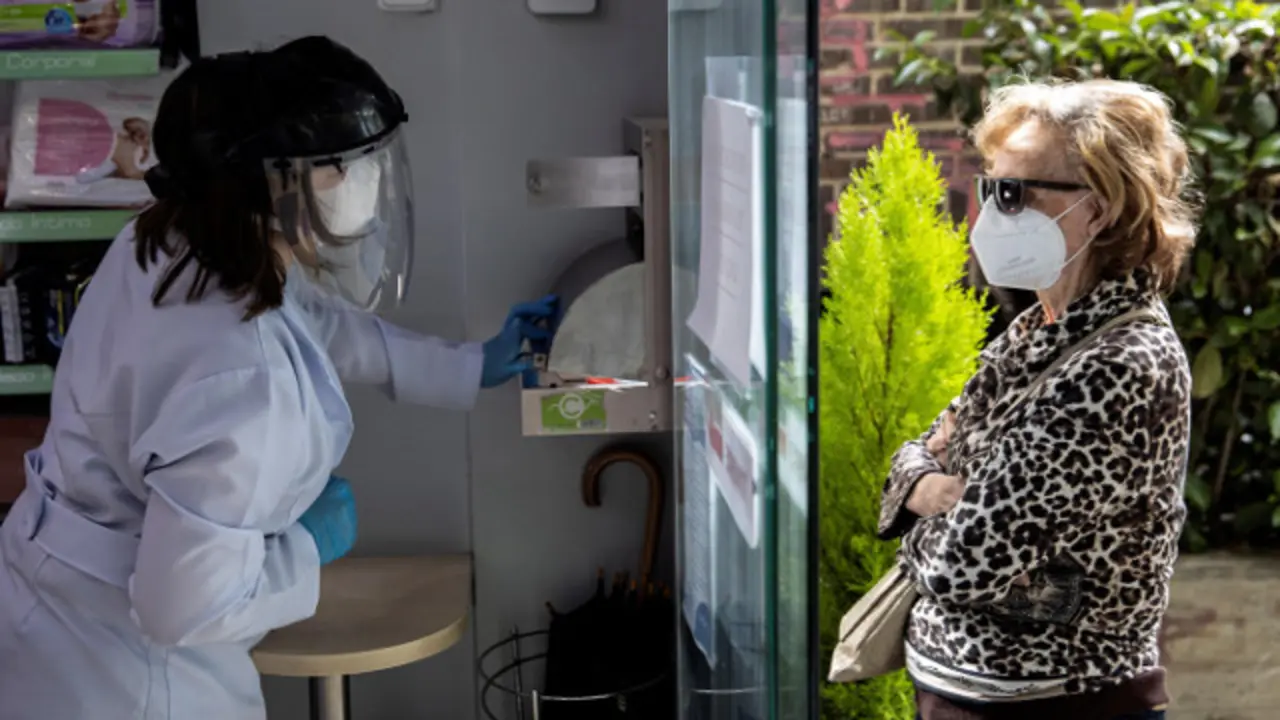 Una mujer con una mascarilla en una farmacia. EFE