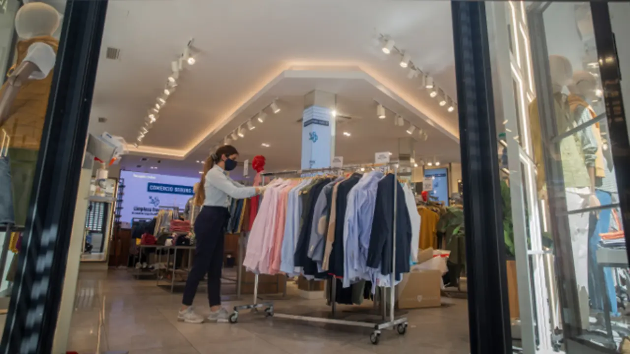 Una empleada en una tienda de ropa. EP