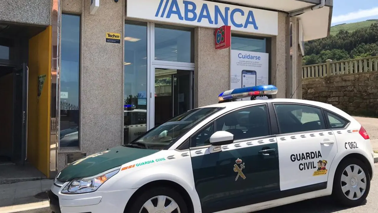 Vehículo de la Guardia Civil frente a la sucursal de Abanca de A Lama, este jueves. RADIO NOVA