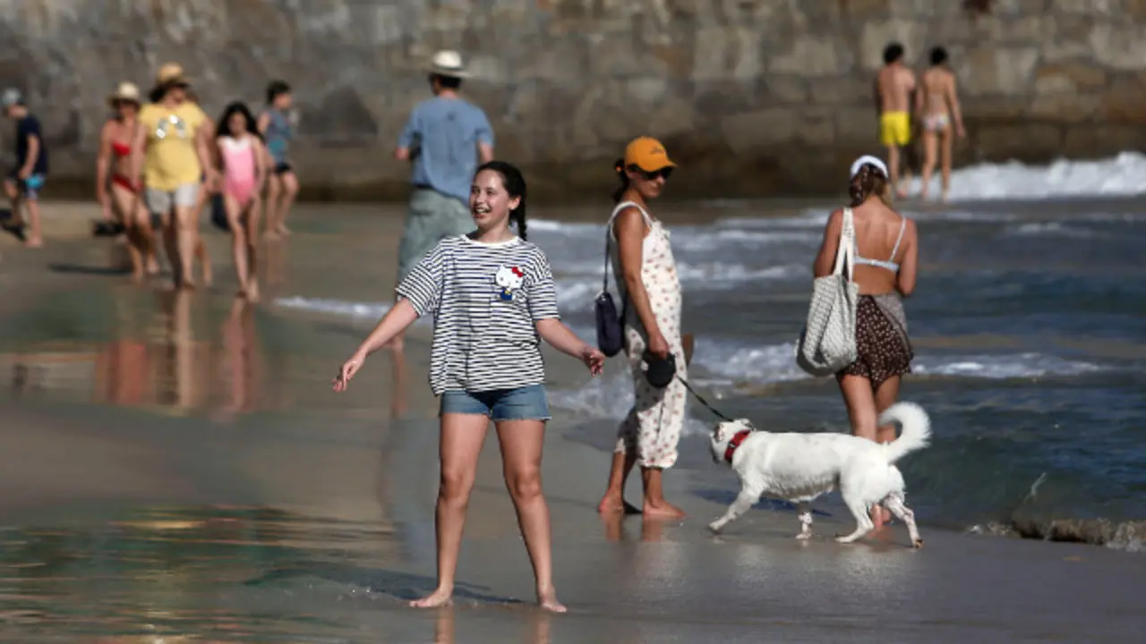 javi terrazas en marin y gente paseando por la playa de silgar, sanxenxo