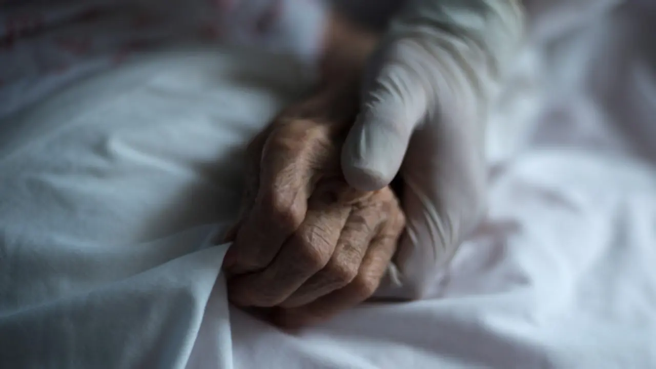 Unha traballadora suxeita a man dunha muller nunha residencia de Celanova. BRAIS LORENZO