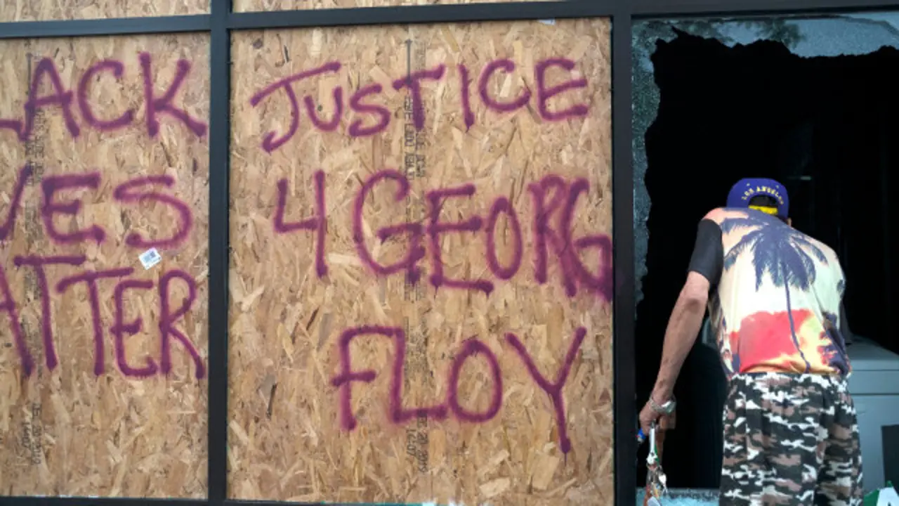 Un hombre supervisa los desperfectos de un negocio tras los disturbios generados tras la muerte de George Floyd en Mineapolis. EFE