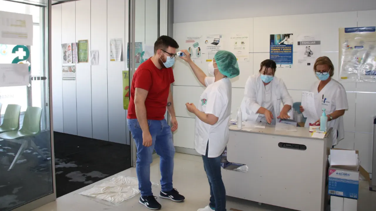 Personal sanitario toma la temperatura a un paciente. EUROPA PRESS