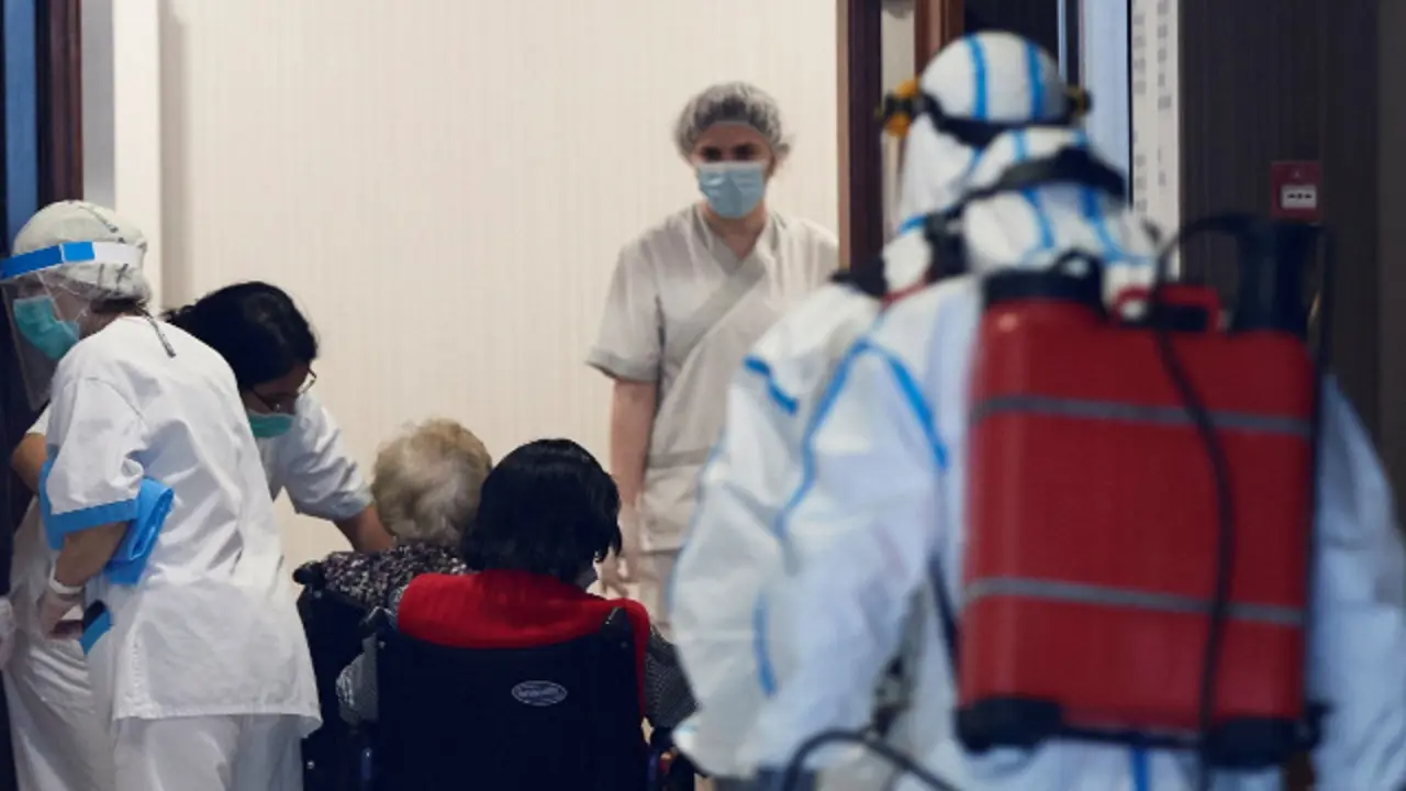 Personal dedicado a la desinfección y a cuidados en una residencia junto a varios usuarios. ARCHIVO