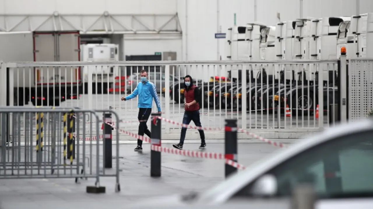 Dos personas con máscara ante la plante de Toennies. EFE