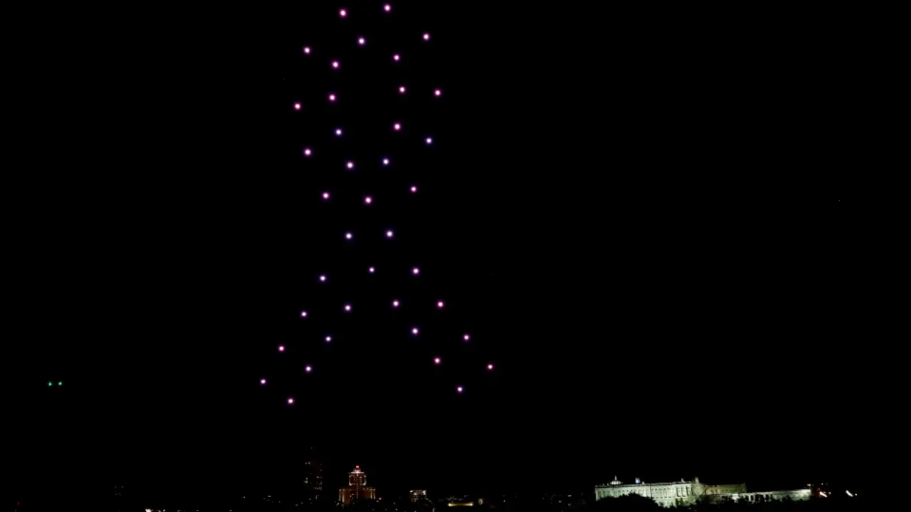 Vista de los 40 drones que este viernes noche iluminaron el cielo sobrevolando el entorno de Madrid R&iacute;o haciendo una coreograf&iacute;a en homenaje a las v&iacute;ctimas del coronavirus. MARISCAL (EFE)