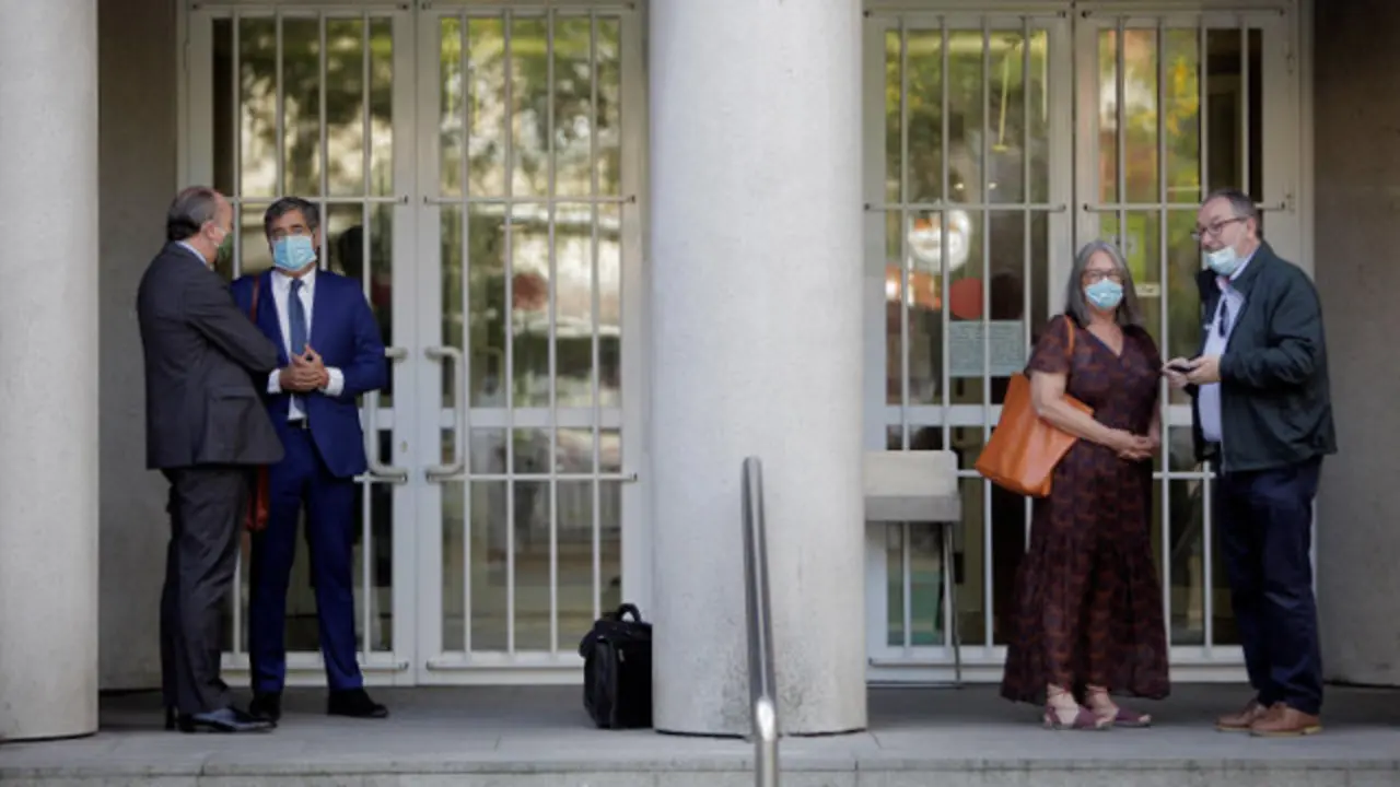 Luis Felipe Utrera-Molina, abogado de la familia Franco, conversa con Miguel Torres, abogado del concello de Sada, mientras la subdelegada del Gobierno en A Coruña, Pilar López-Rioboo, se encuentra al otro lado de la columna, momentos antes de iniciarse una nueva sesión del juicio por la propiedad del Pazo de Meirás. EFE