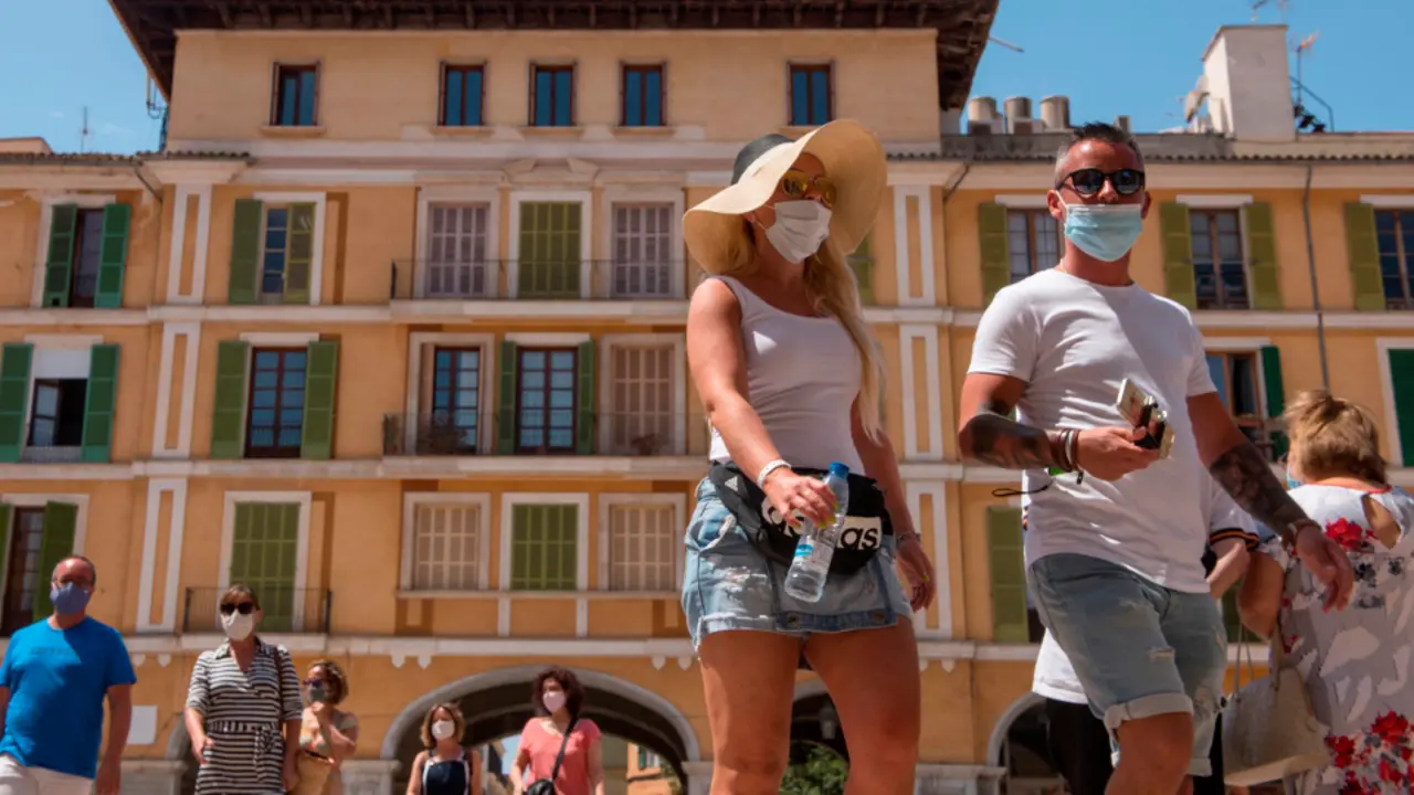 Transeúntes se protegen con mascarillas por las calles de Palma de Mallorca. ATIENZA (EFE)