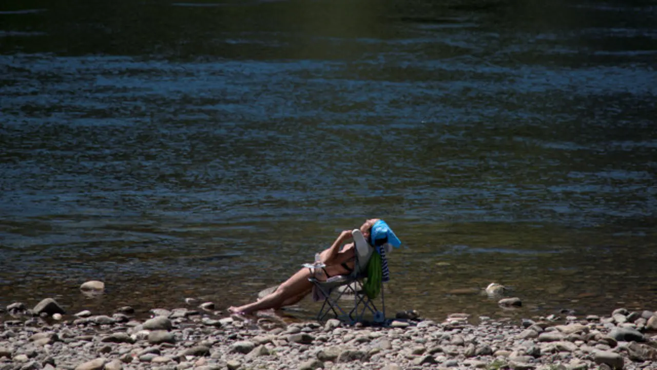 Unha muller toma o sol na praia fluvial do Miño, en Ourense. BRAIS LORENZO (Efe)