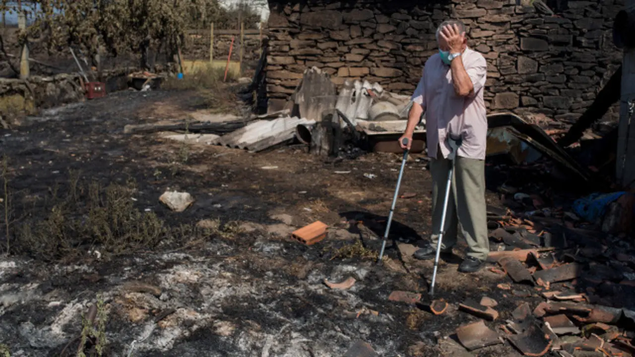 Un vecino se lamenta de los daños provocados por el fuego en Cualedro. BRAIS LORENZO (Efe)