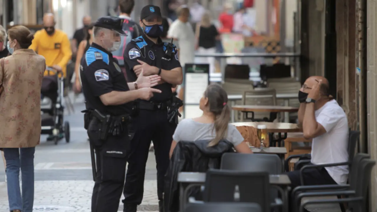 Dos agentes avisan a una pareja de la obligatoriedad del uso de la mascarilla. CABALAR