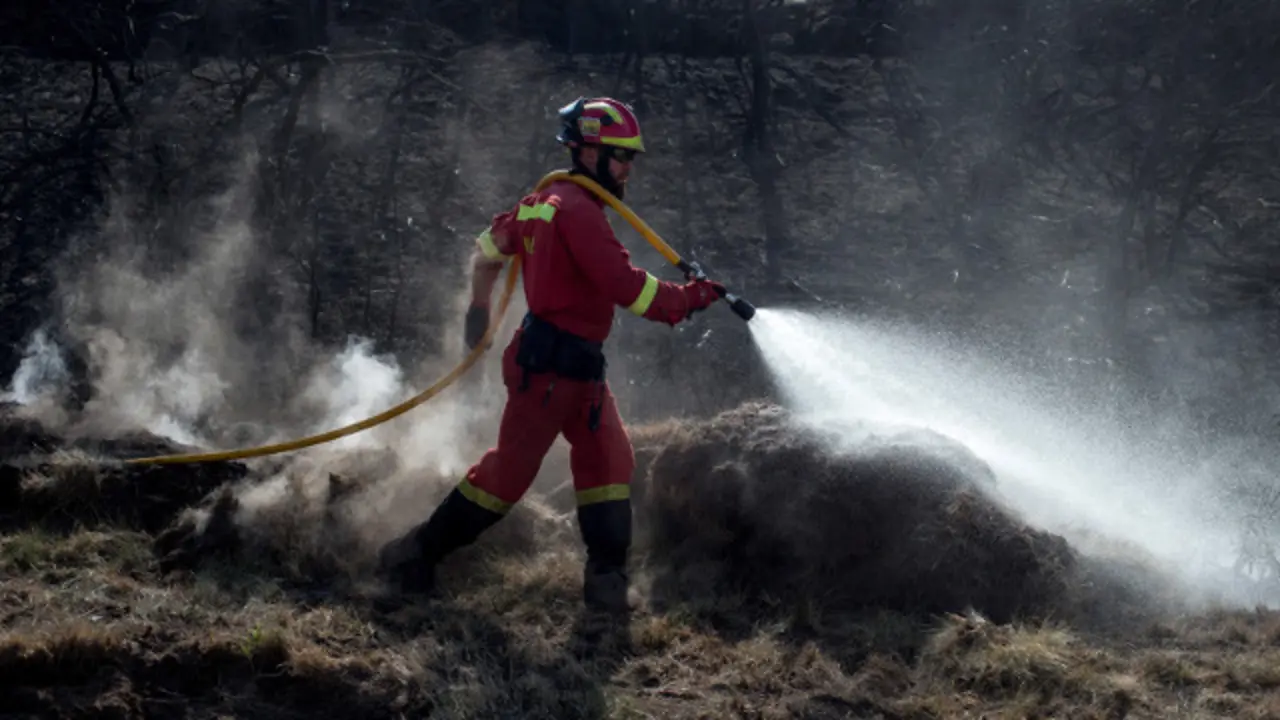 Un efectivo da Ume apaga un lume en Cualedro. BRAIS LORENZO