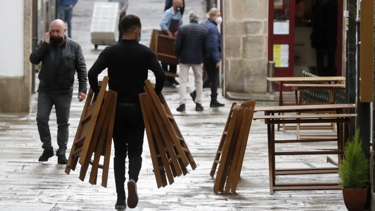 Un hombre monta una terraza en Compostela. LAVANDEIRA JR. (EFE)