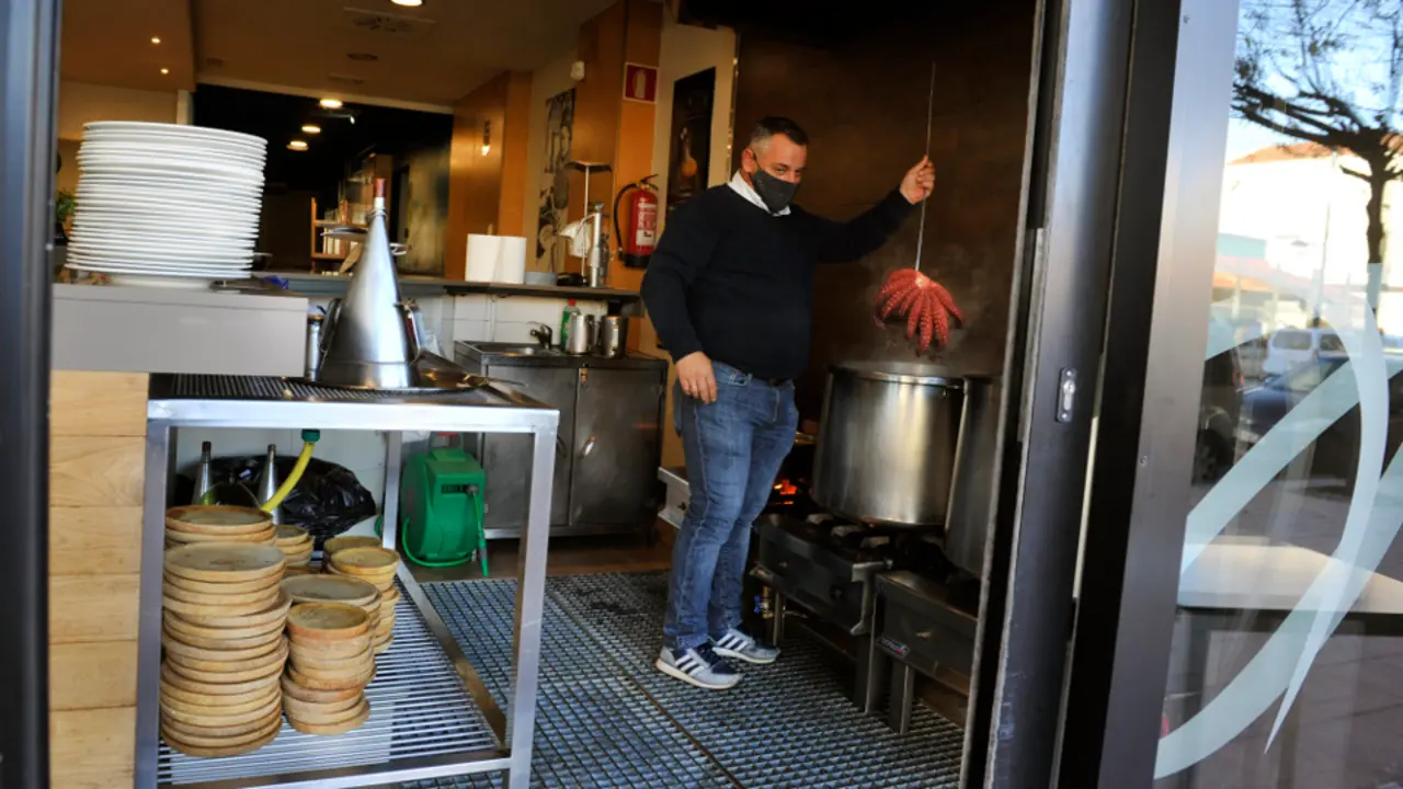 Un home cociñando polbo, no Carballiño. EUROPA PRESS