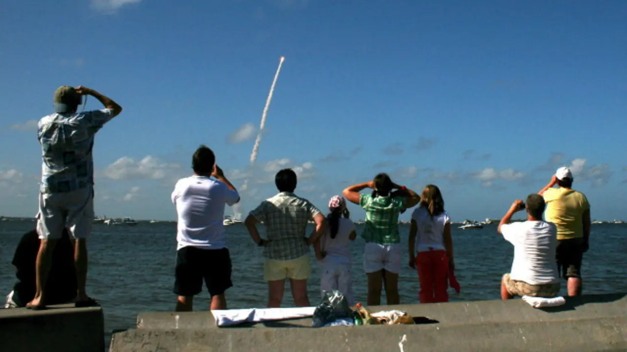 Turistas observan o cabelo branco que sae da orella do autor. Outras fontes, quizais máis fidedignas, apuntan que a imaxe se corresponde en realidade coa engalaxe do 'Discovery' en 2006 desde Cabo Cañaveral. ARQUIVO