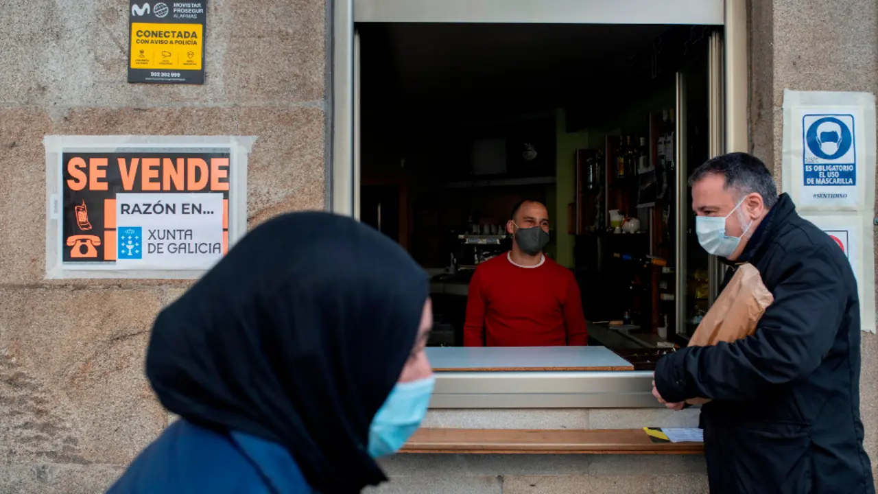 El camarero de un bar de Ourense habla con un cliente. BRAIS LORENZO (EFE)