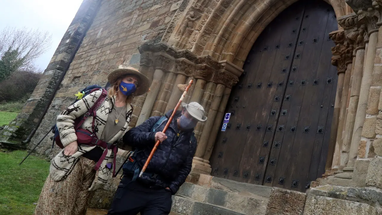 Dos peregrinos pasan junto a una iglesia. ANA F. BARREDO (EFE)