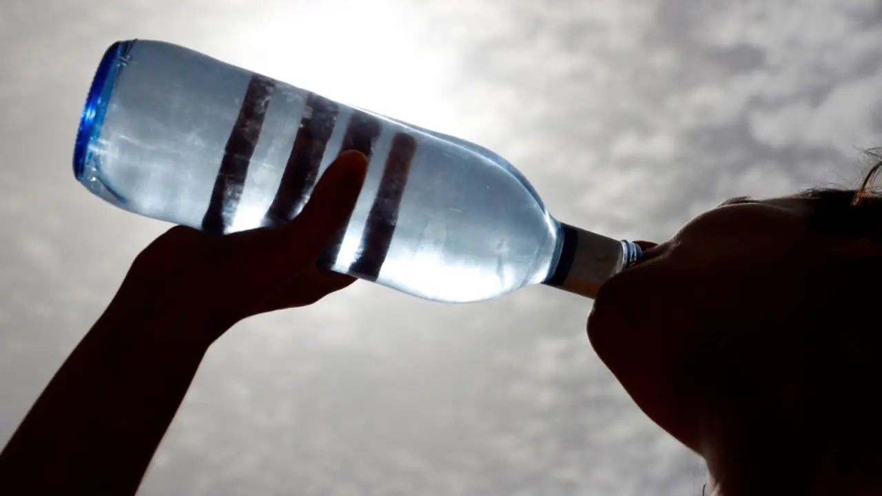 Una mujer bebe agua en la calle. EFE