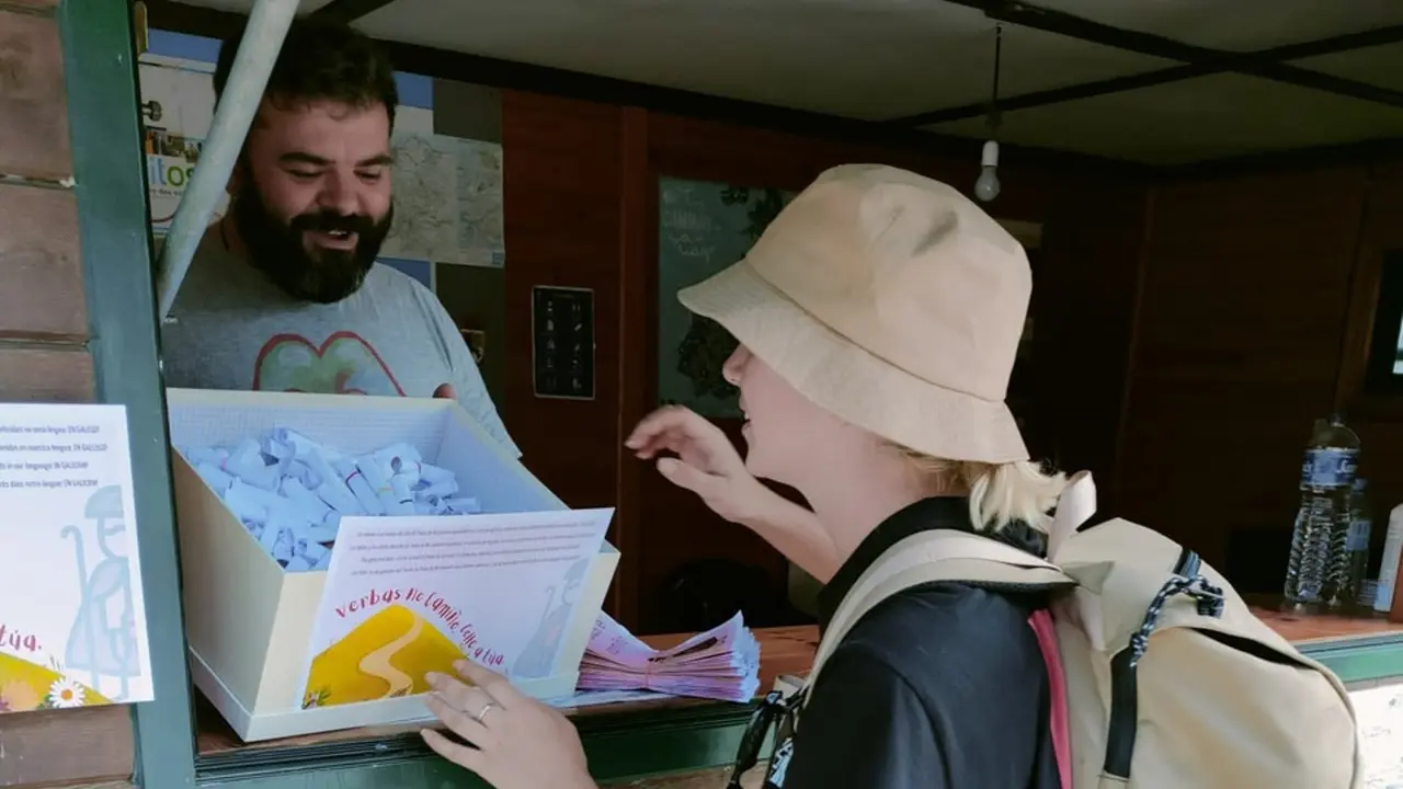 Unha peregrina colle unha das tarxetas que os estudantes agasallan. EP