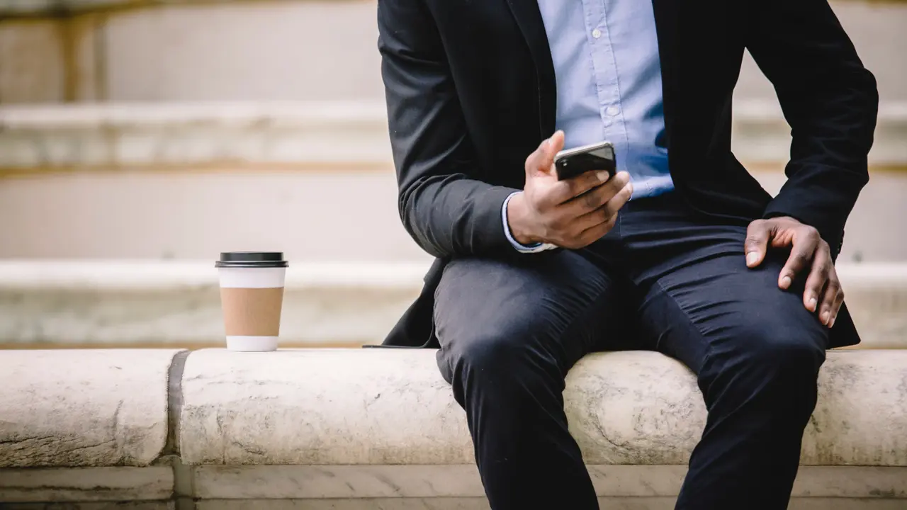 Un chico mira su teléfono móvil
