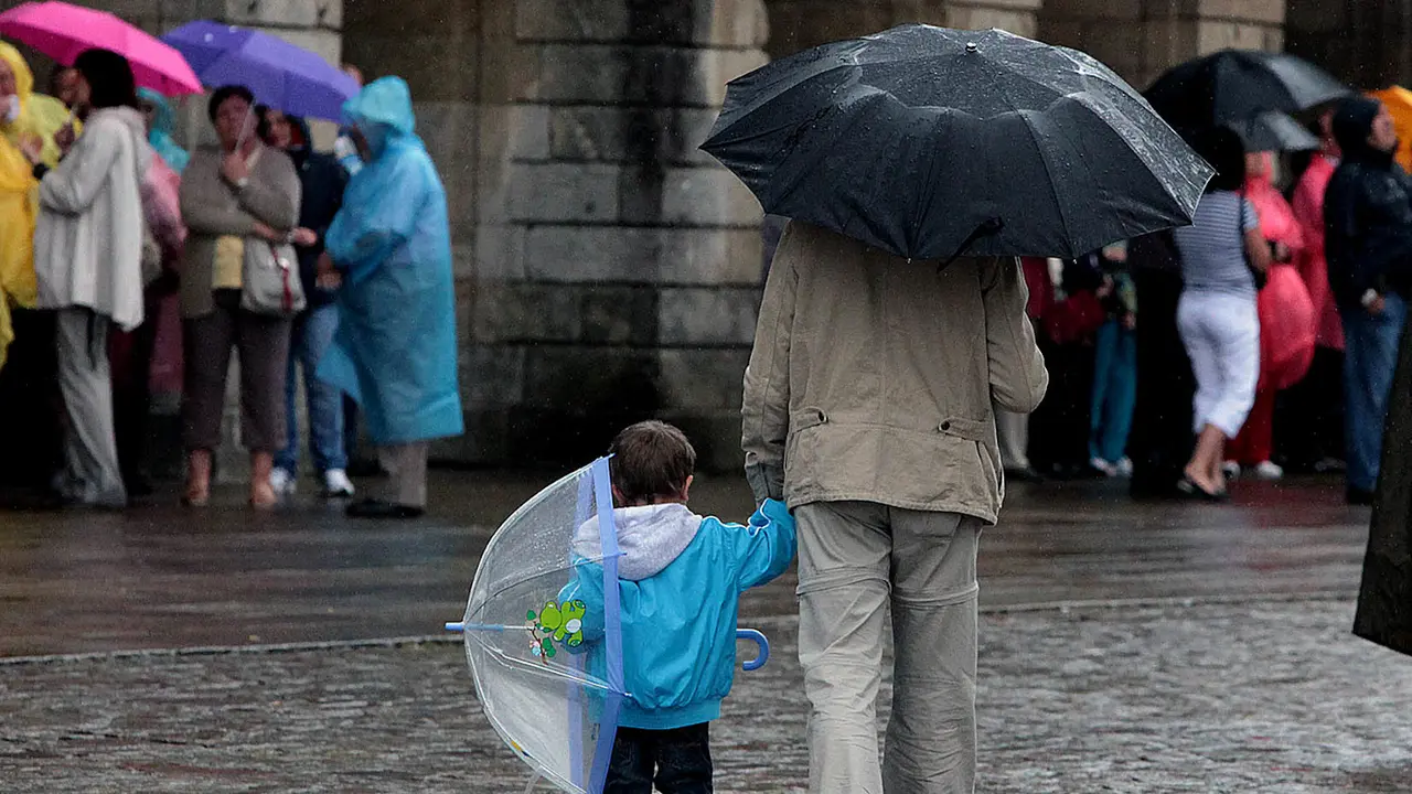 Varias personas bajo la lluvia en Santiago. ARCHIVO