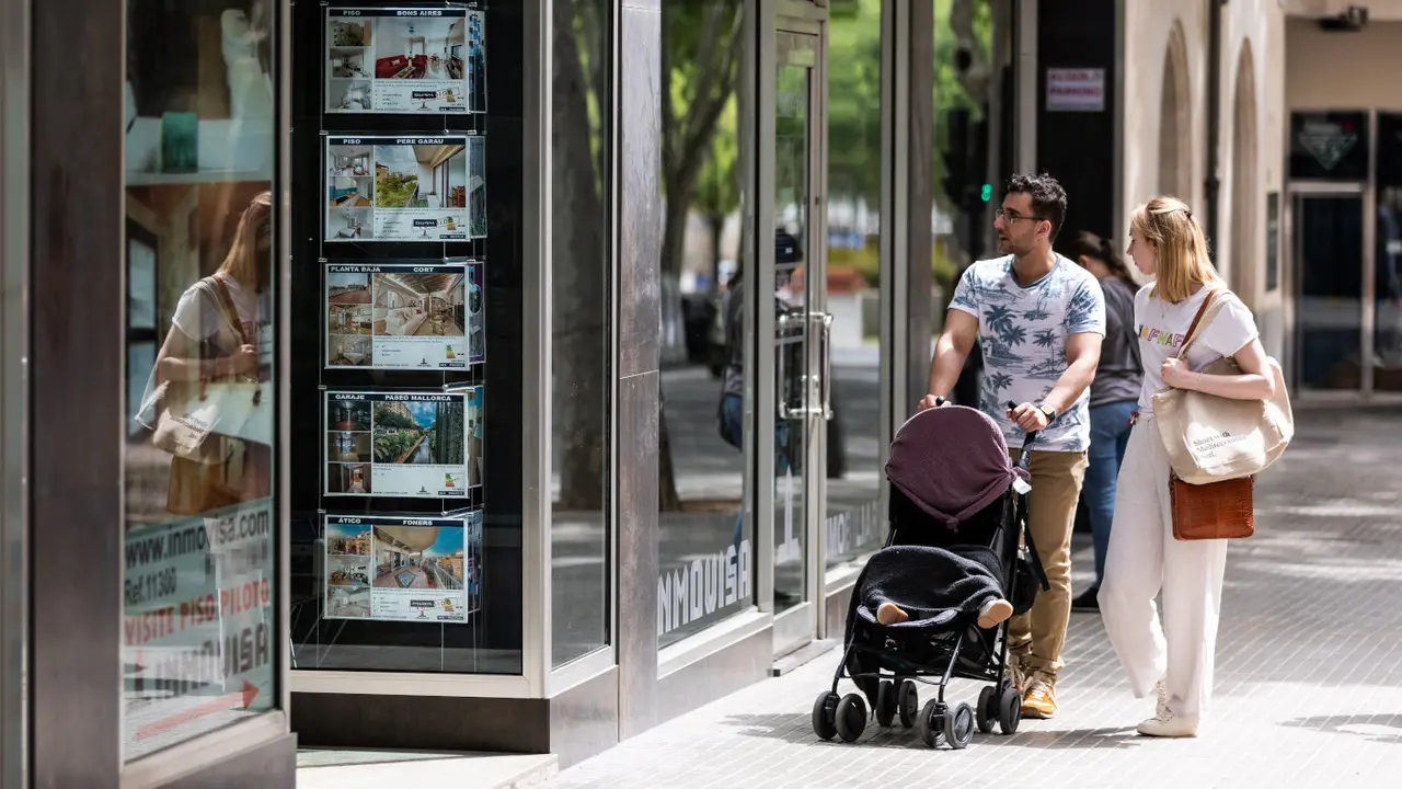 Una pareja pasa ante una inmobiliaria. EUROPA PRESS