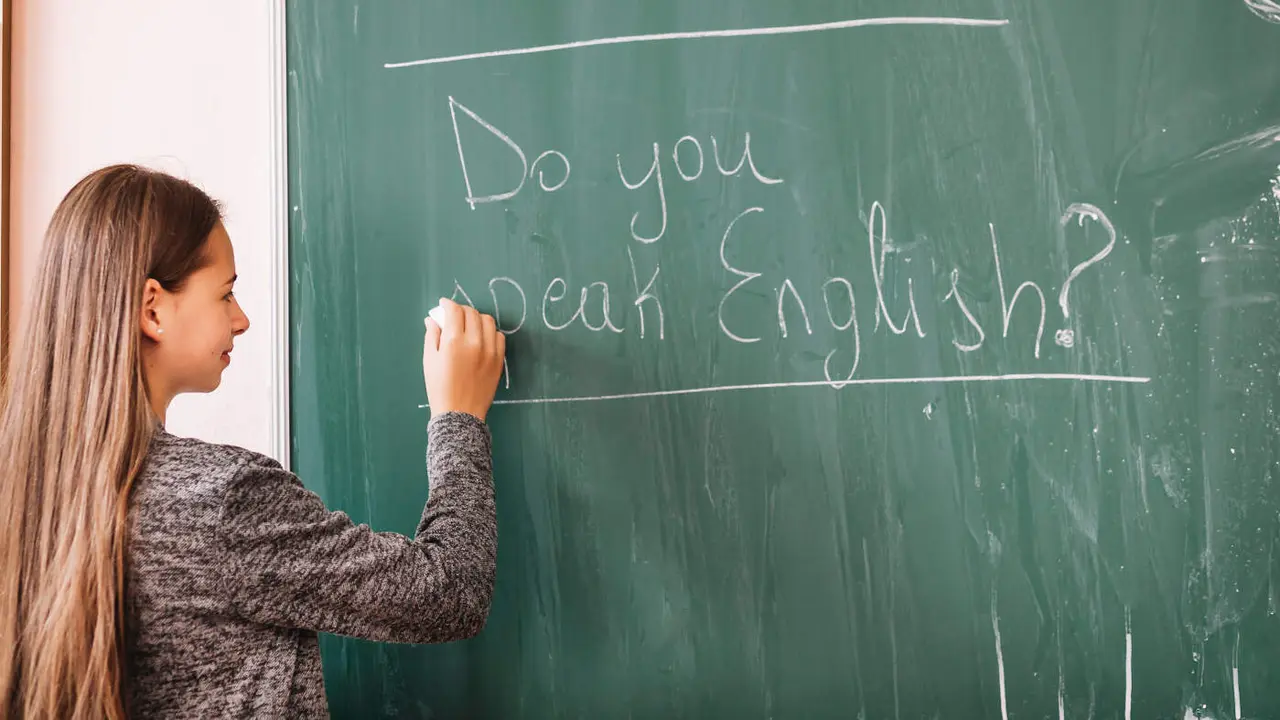 Una mujer escribe en una pizarra.Freepik