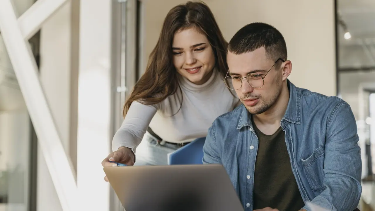 Dos becarios en una oficina. FREEPIK