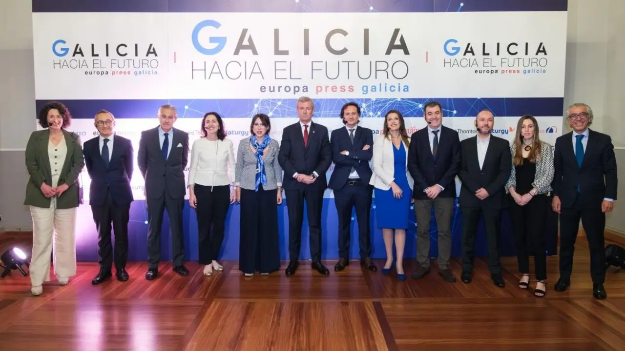 Alfonso Rueda, flanqueado por los participantes en el foro compostelano. EP