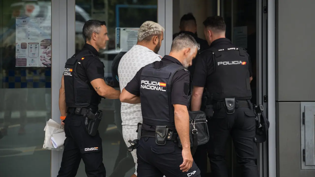 Uno de los detenidos por la reyerta en Ribeira custodiado por varios agentes. EUROPA PRESS