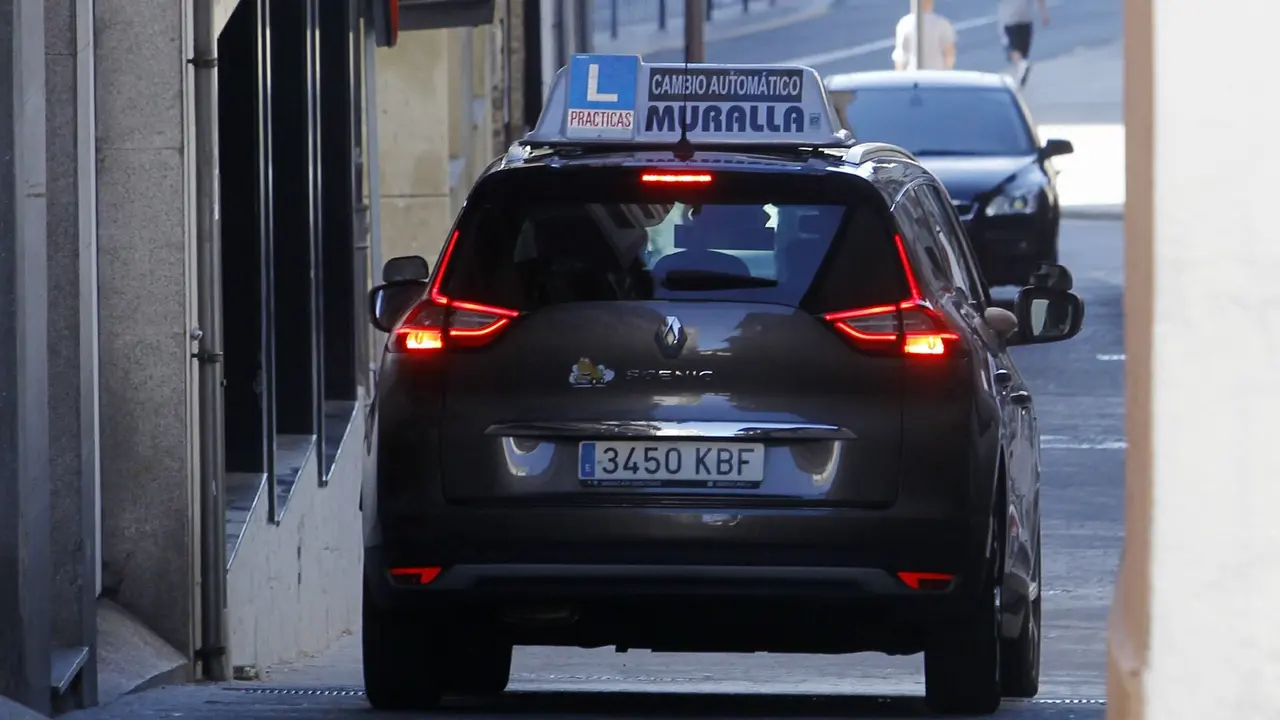 Un coche de autoescuela baja por una calle en el barrio de Recatelo, en Lugo. SABELA FREIRE