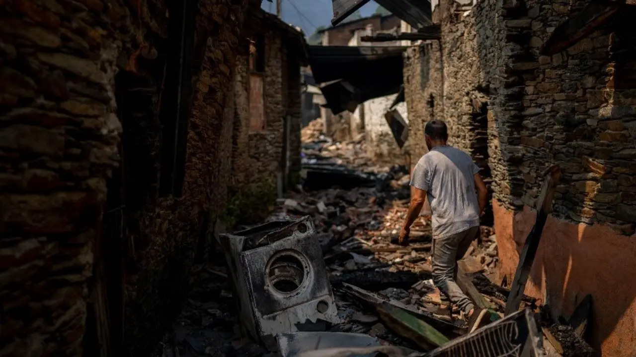 Un vecino camina entre los escombros en Cernego, en Vilamartín de Valdeorras. BRAIS LORENZO